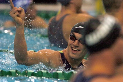 Swimmer Matt Targett in pool gesturing with smile