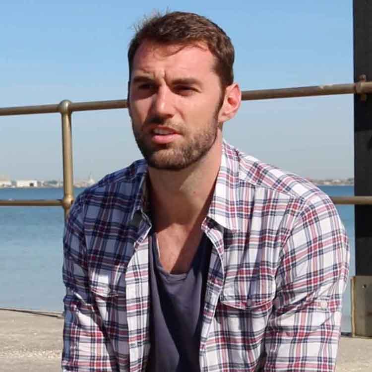 Swimmer Matt Targett sitting on pier at beach